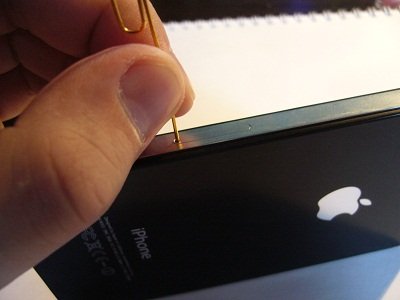 Turite spustelėti mažą, tvarkingą skylę „iPhone“ šone, tada atsidarys jungtis, kuri tiesiog nukreipta į tai, kad joje bus SIM kortelė
